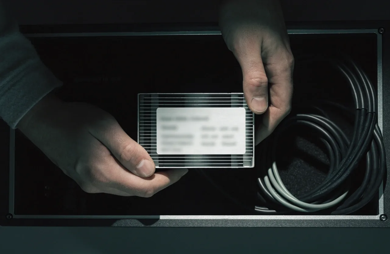 Hands holding a power supply unit so its label can be checked inside an open computer case