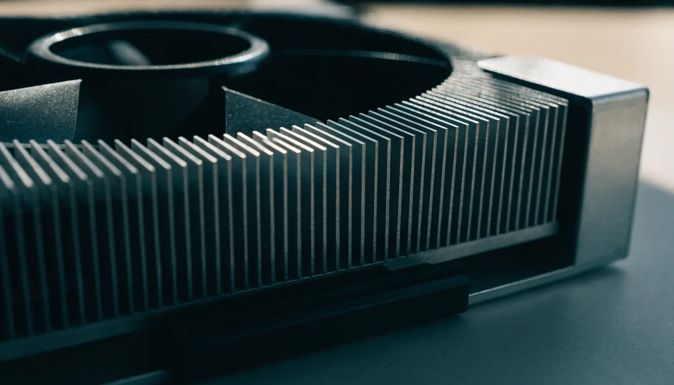 Close crop of a graphics card cooler edge showing fins, fan hub and backplate corner