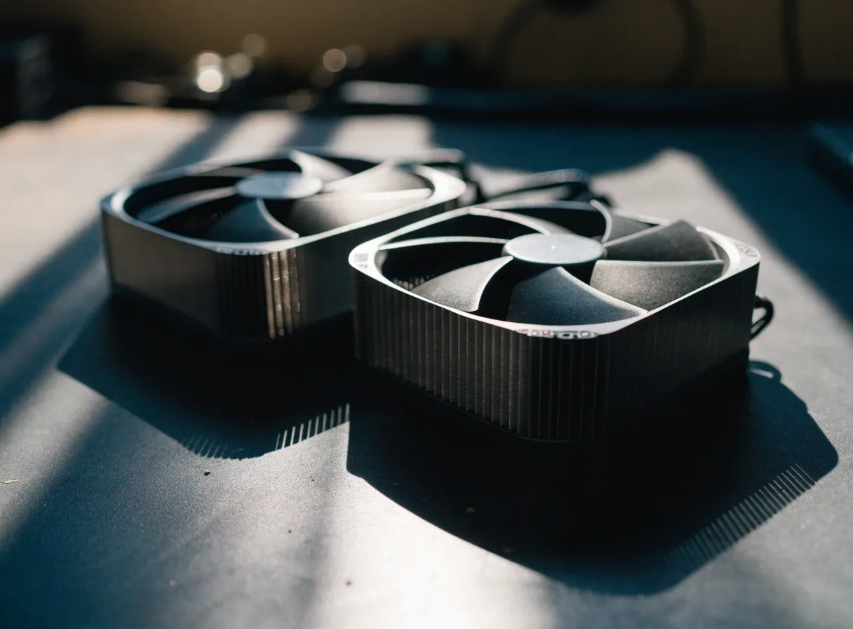 Two graphics card coolers on a work counter under raking light